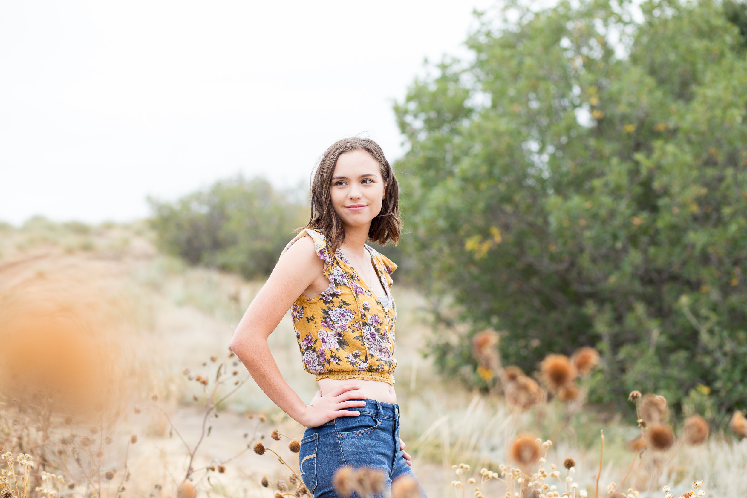 Colorado Springs Senior Photography | Doherty High School | Stacy Carosa Photography | Senior girl smiling at camera surrounded by tall grasses in the fall