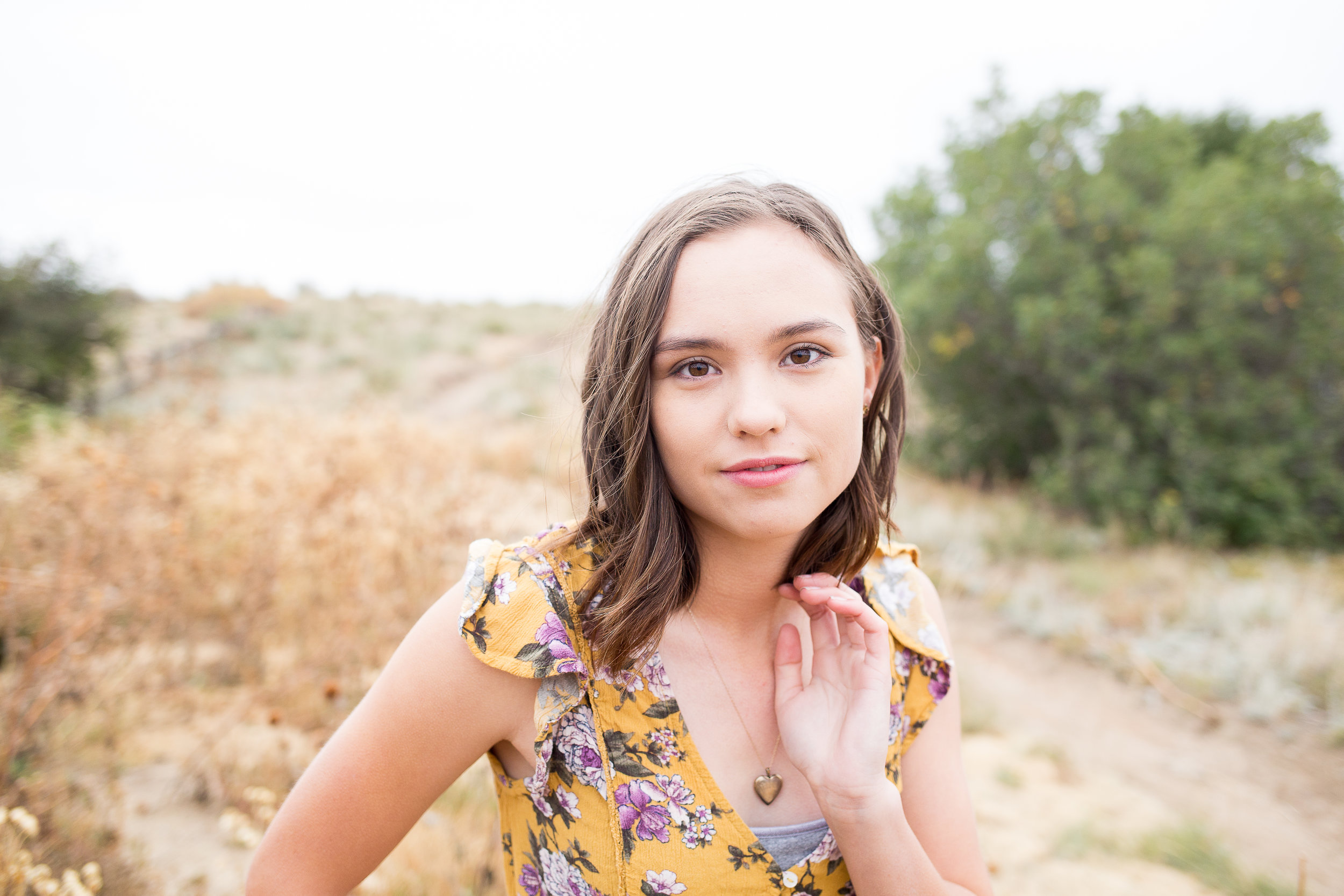 Colorado Springs Senior Photography | Doherty High School | Stacy Carosa Photography | Senior girl smiling at camera surrounded by tall grasses in the fall