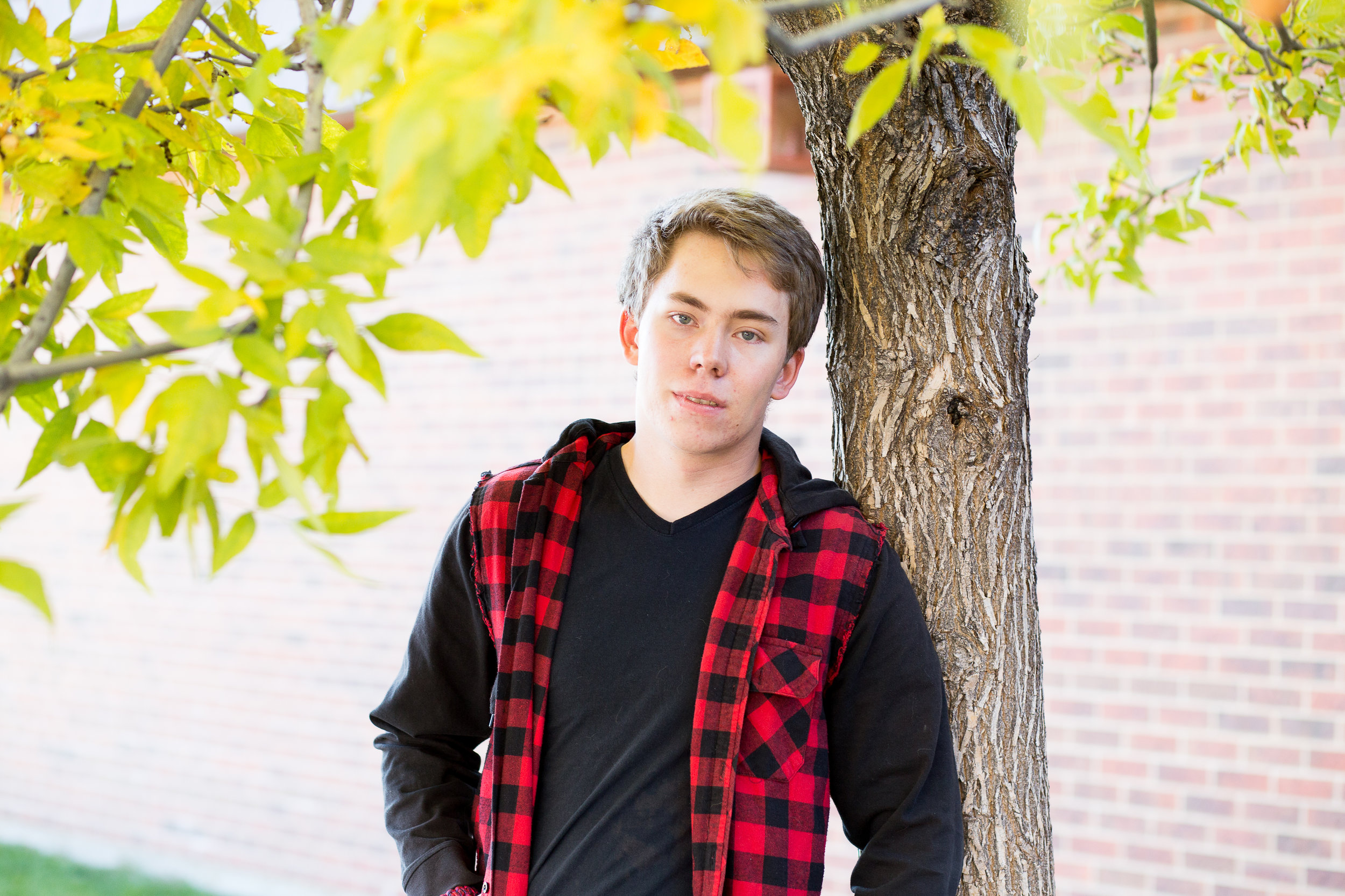 Stacy Carosa Photography | Colorado Springs Senior Photographer | senior boy standing near brick building for senior session photos in the fall