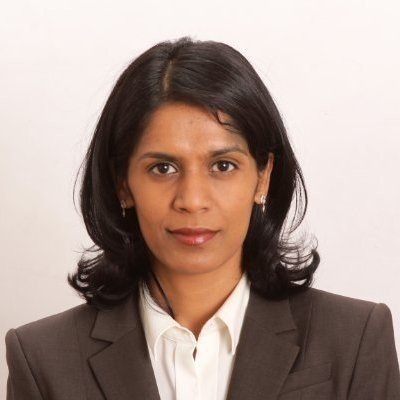 A professional woman with shoulder-length black hair, wearing a dark blazer and white shirt, posing against a plain white background.