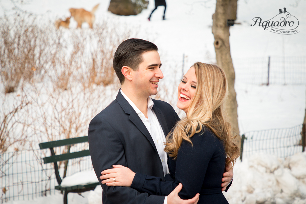 engaged couple laughing in snowy Central Park