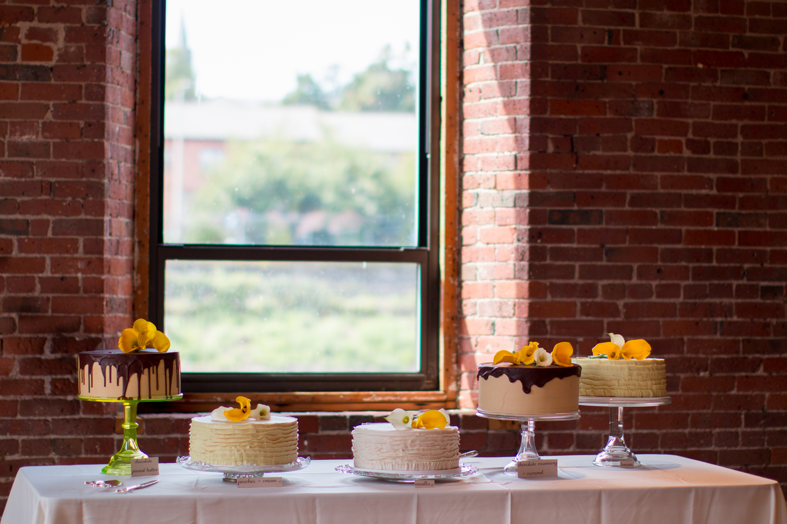 pretty cake table against brick wall