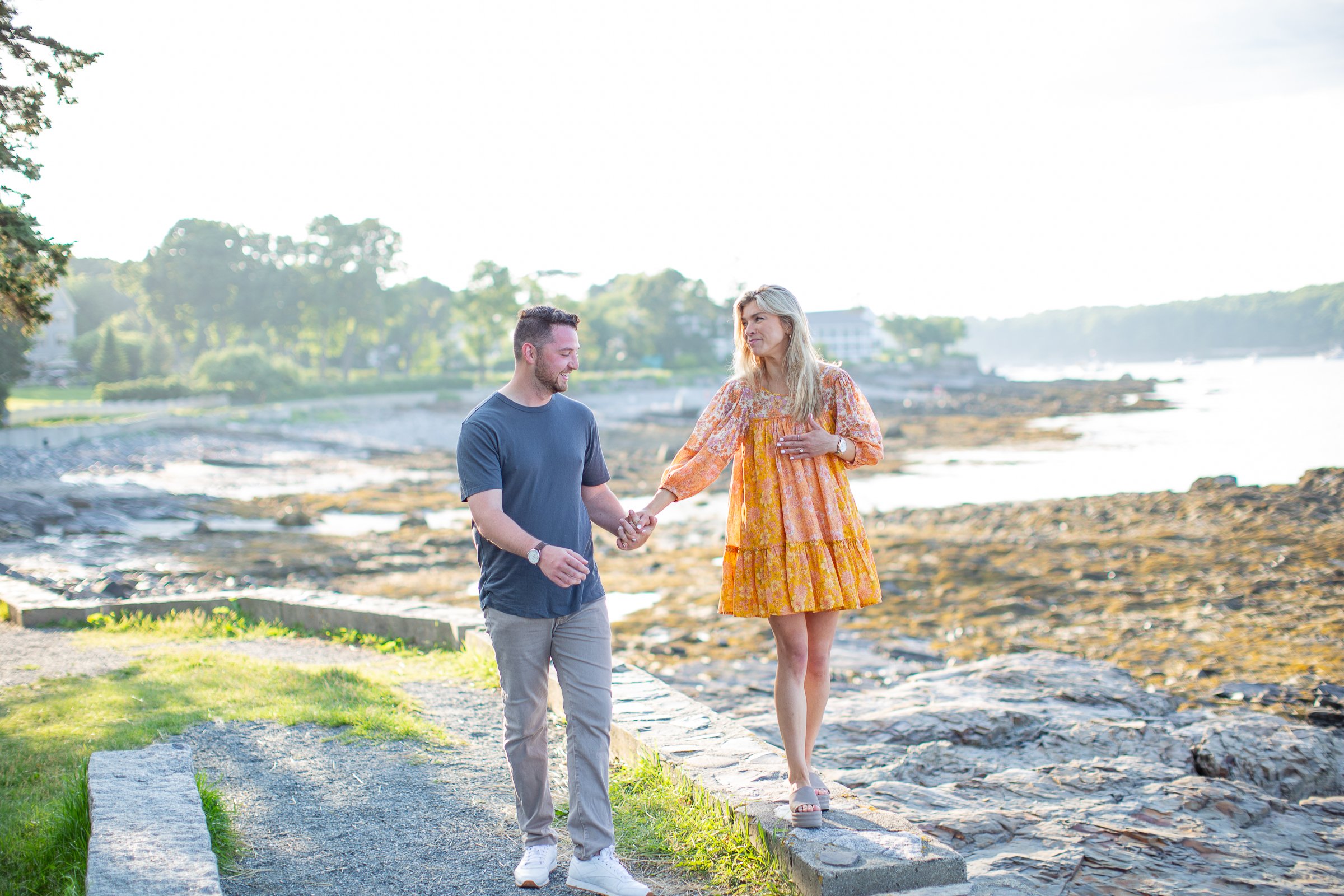  A couple enjoys a surprise proposal and engagement photo session at the Shore Path in Bar Harbor on Mount Desert Island near Acadia National Park, Maine. 