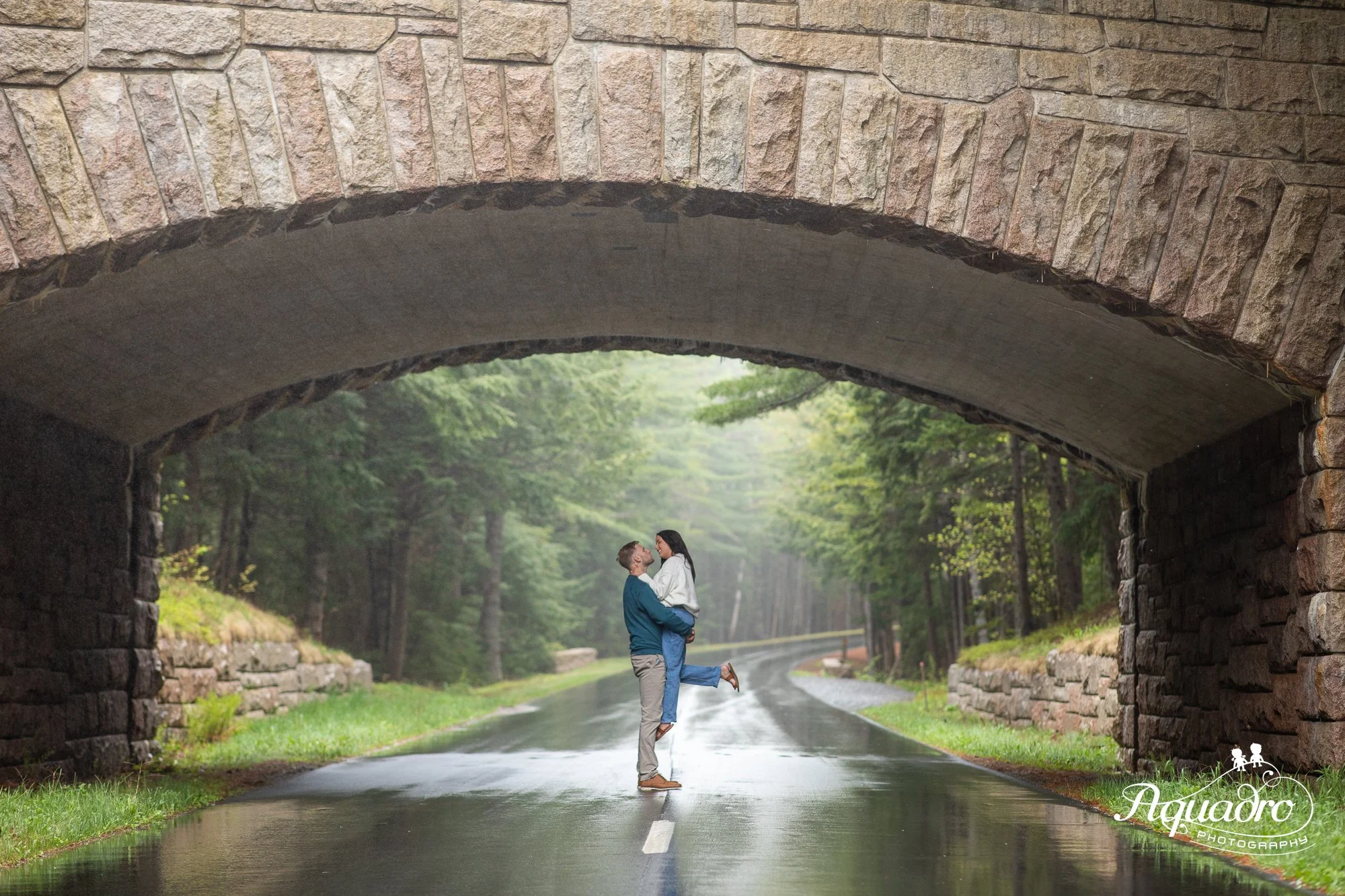 couple under carriage road bridge in acadia national park on mount desert island maine