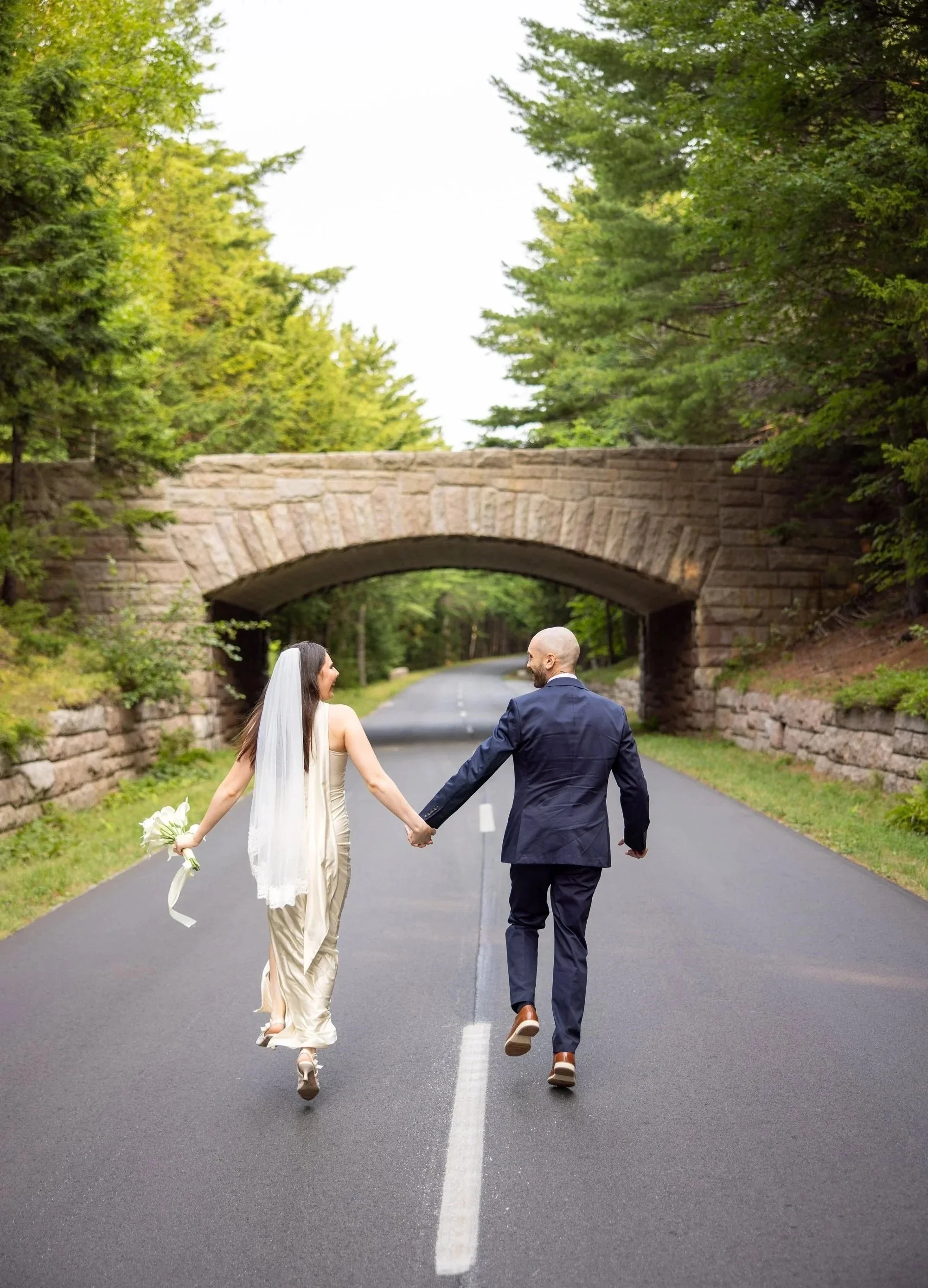 bride and groom on the Acadia park loop road on their wedding day