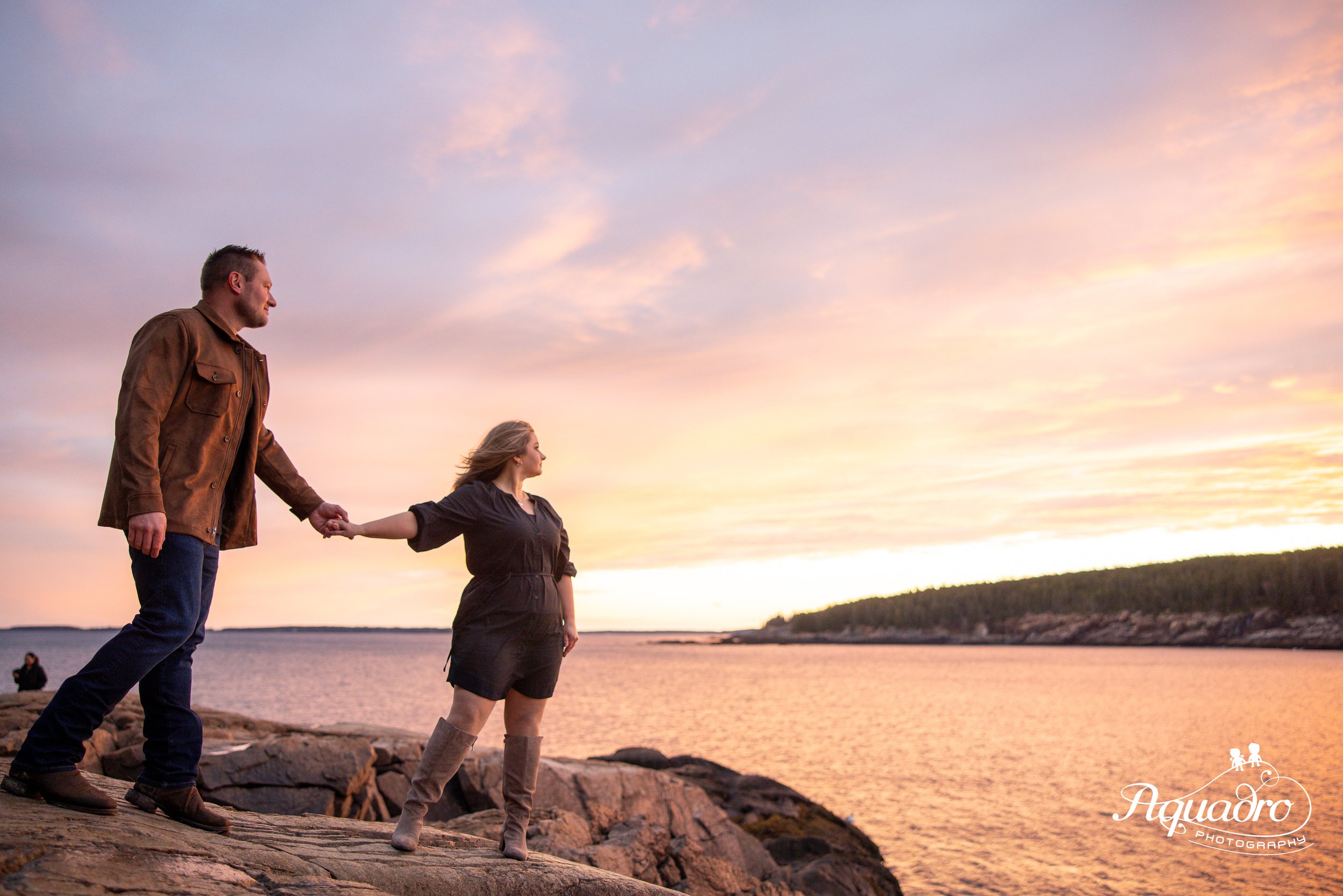 couple at sunset at otter point in acadia national park for anniversary photo session