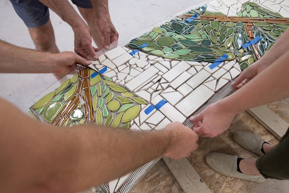  Because the mosaic had to be cut into sections so that it could be lifted and placed on the bench, blue painters’ tape was used as registration marks so that each piece could be aligned correctly.  Photo by Michael Spooneybarger 