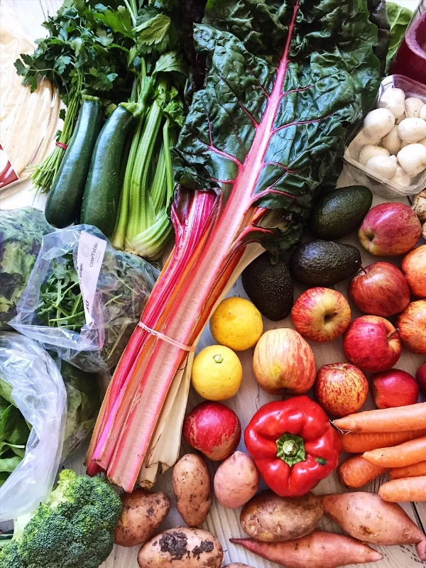 A farmers market shop - zuchini, herbs, celery, swisse chard, mushrooms, avocados, lemons, red pepper, kumara, potatos, apples, rocket, salad, brocolli.