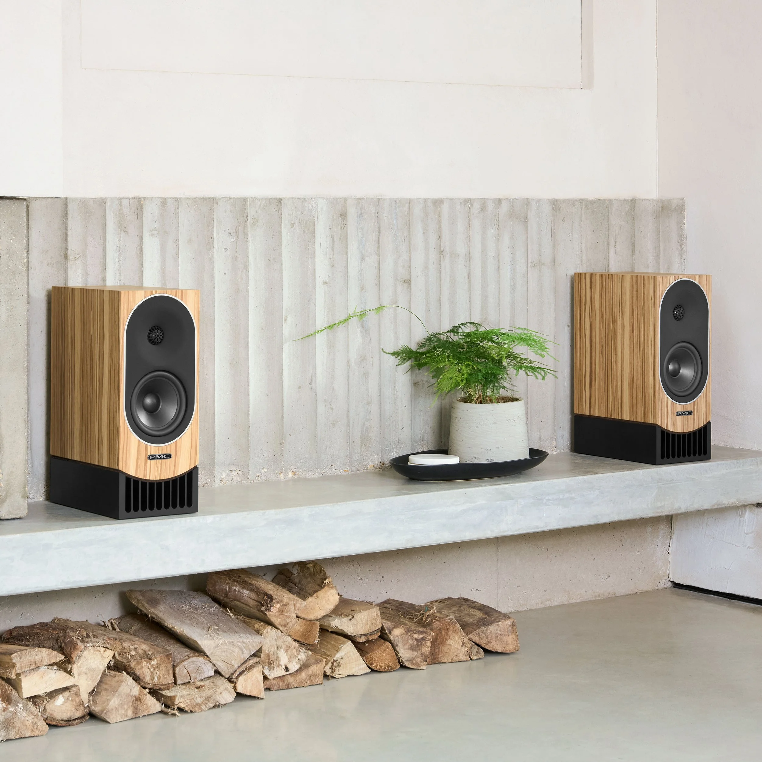 PMC prophecy1 bookshelf speakers in mediterranean oak shown on a white mantle.