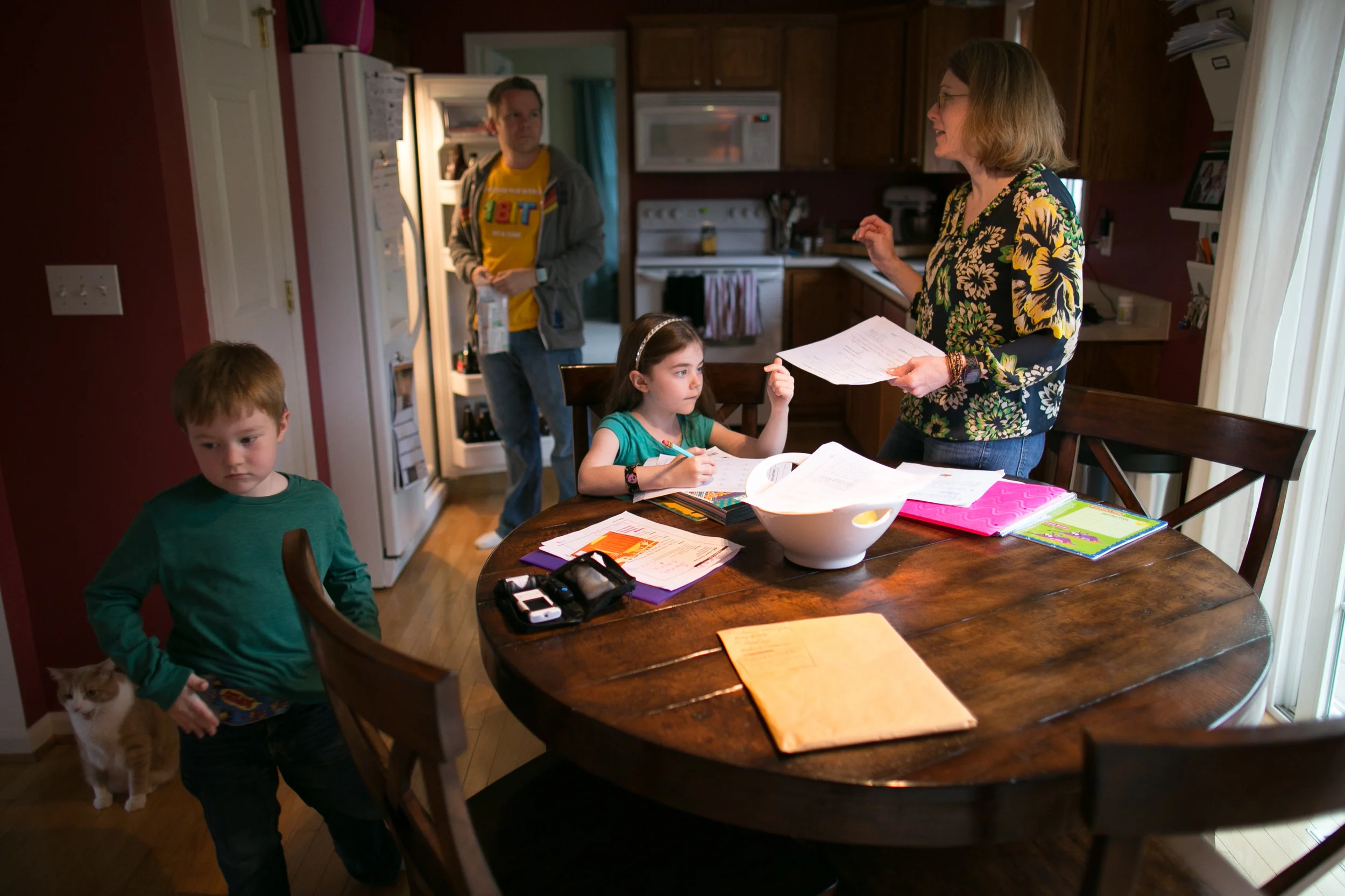 Evan, John, Sarah, and Laura gather in the kitchen before dinner at their home.