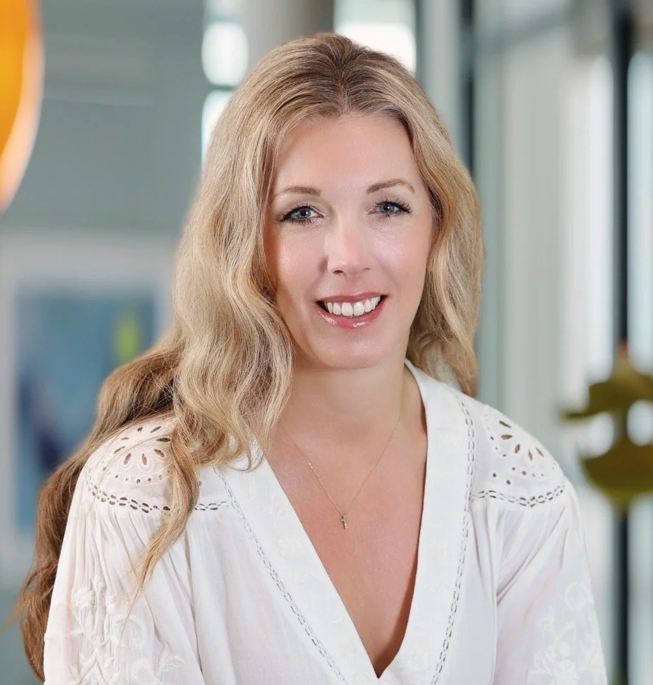Jacqueline Fisch, writing with the moon author in a white flowy top and long blonde hair, smiling