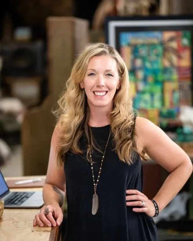 Jacqueline Fisch Author Photo in a black dress with art in the background