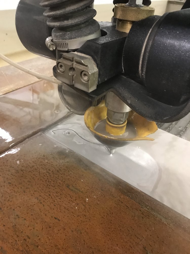 closeup shot of a waterjet cutter cutting a blade.JPG