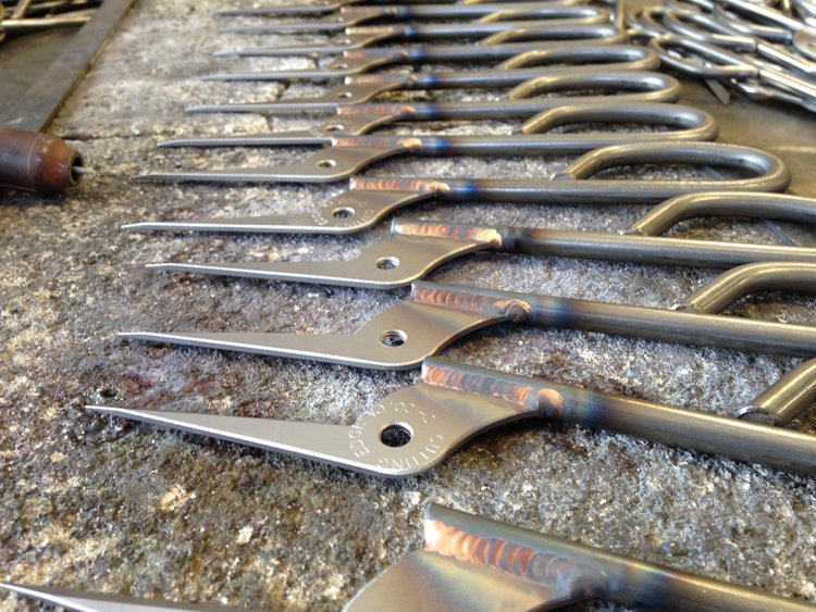 row of 12 single sides of shears neatly laying on a metal table.JPG