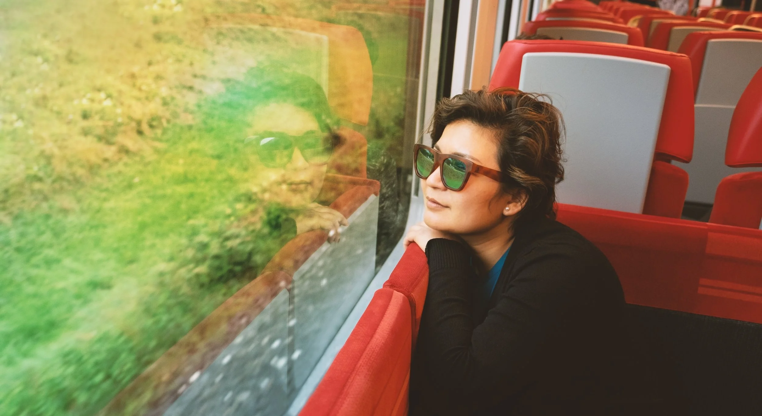 upper-section-portrait-of-a-female-traveller-sitting-on-red-seat-in-a-train-that-moving-along_t20_oopxLk.jpg