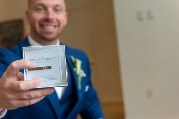 Groom smiling and holding a wedding gift for the bride