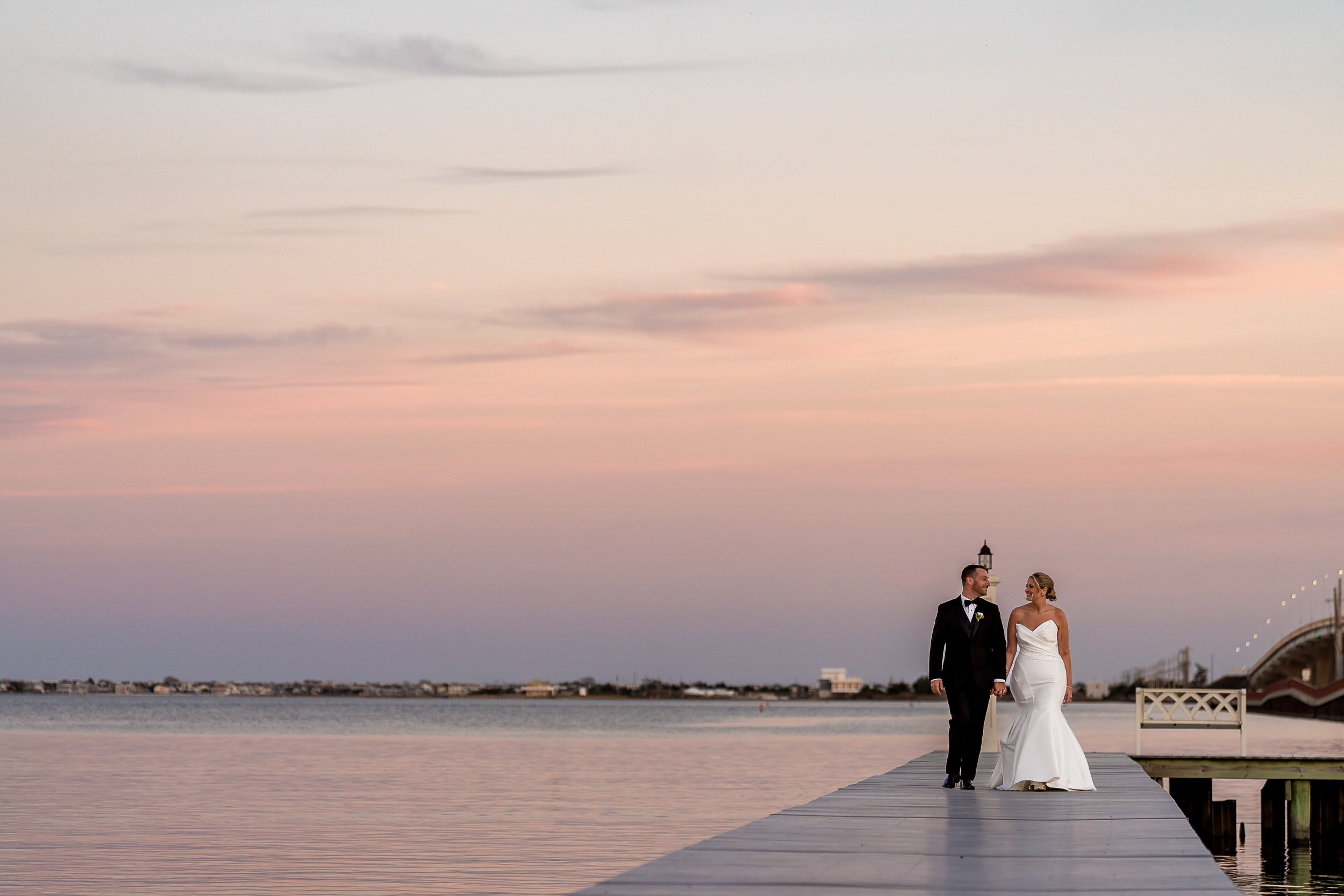 Newlyweds walking along the dock at Mallard Island Yacht Club with waterfront views