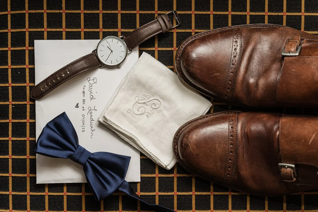 Groom’s shoes, watch, bow tie, and handkerchief details before wedding