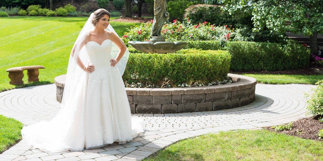 Bride posing outdoors on the landscaped grounds of The Tides estate wedding venue