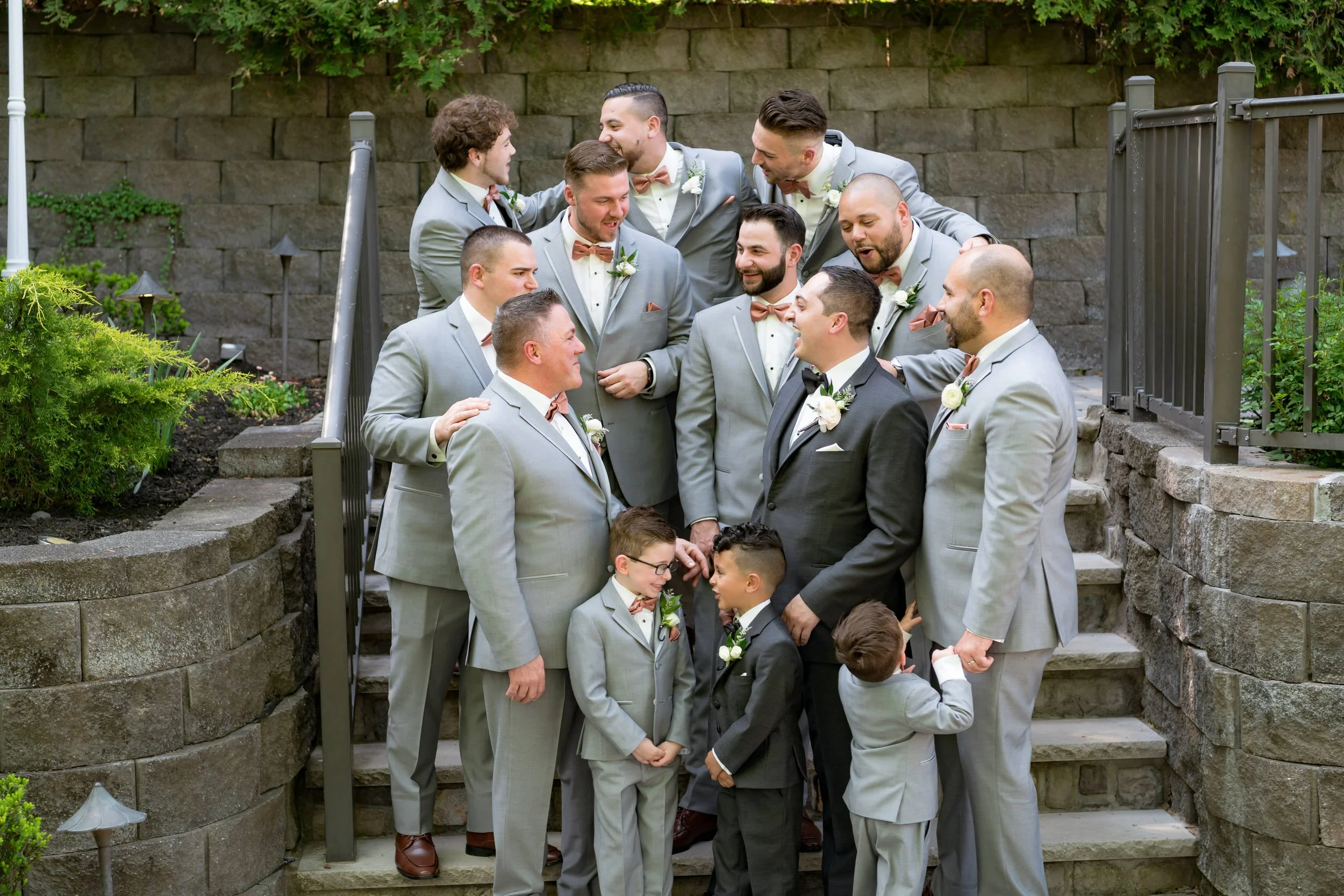 Groomsmen laughing together on outdoor steps at Valley Regency wedding