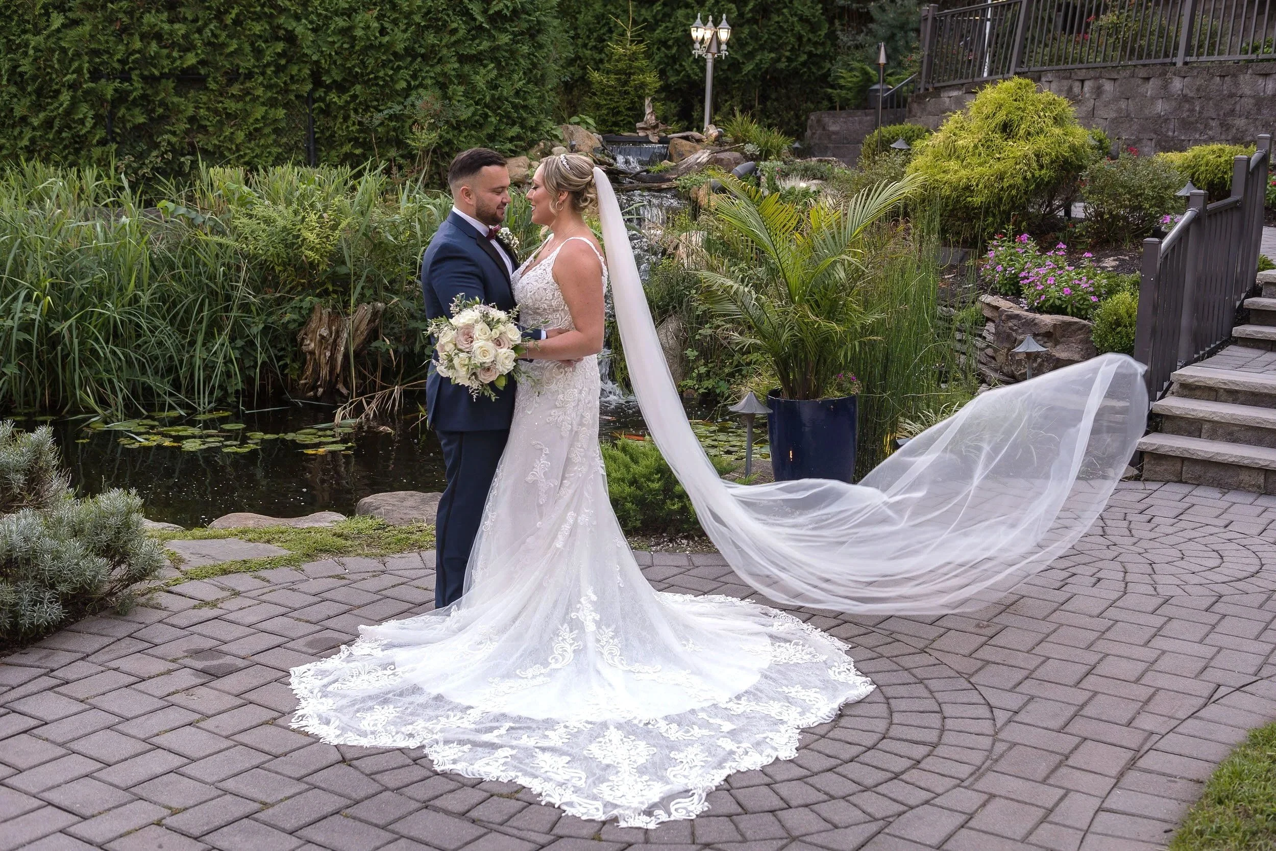 Bride and groom portrait in garden pathway with long train at Valley Regency