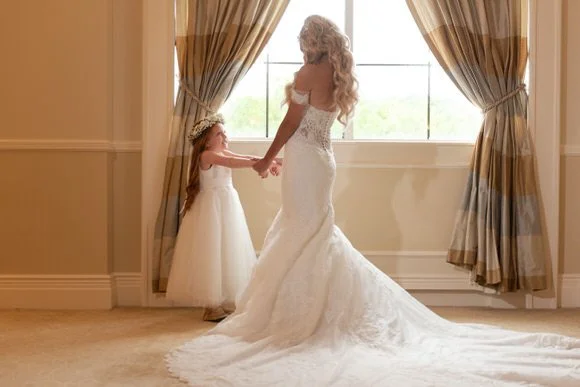 Bride sharing a sweet moment with her flower girl before the ceremony