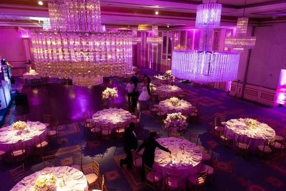 Reception tables and floral centerpieces under lighting at The Grove