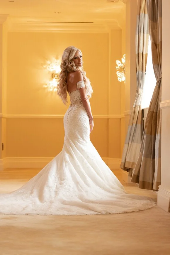 Bride posing near a sunlit window in her gown captured by Jason Giordano Photography
