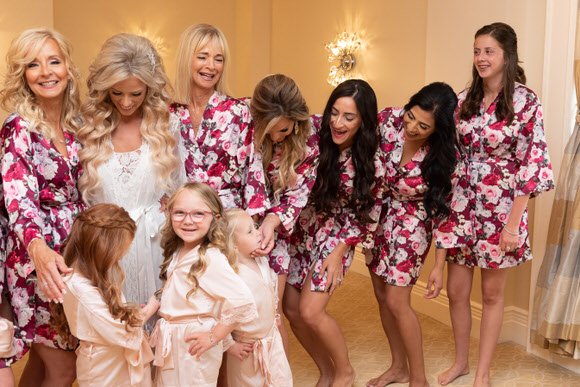 Bride with bridesmaids and flower girls wearing matching robes before the wedding