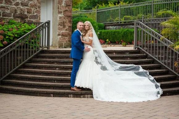 Couple posing on elegant stone staircase at a luxury North Jersey venue