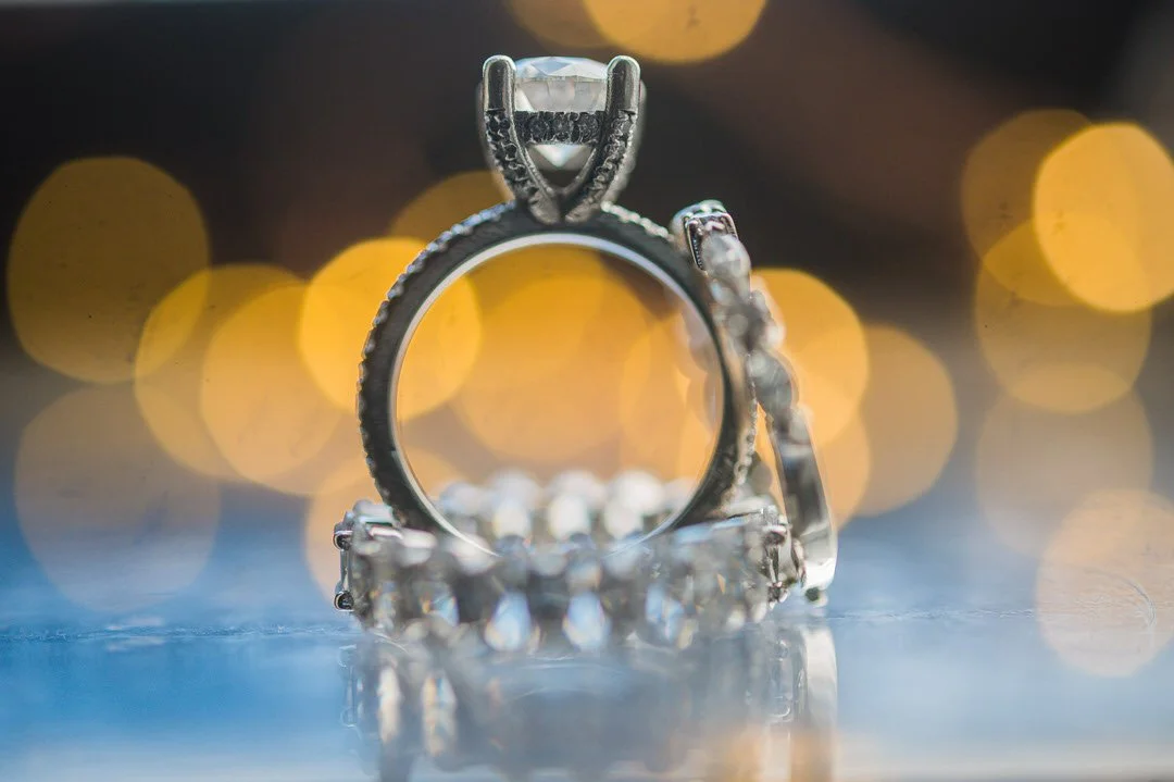 Close-up of diamond wedding ring with bokeh lights at The Brownstone