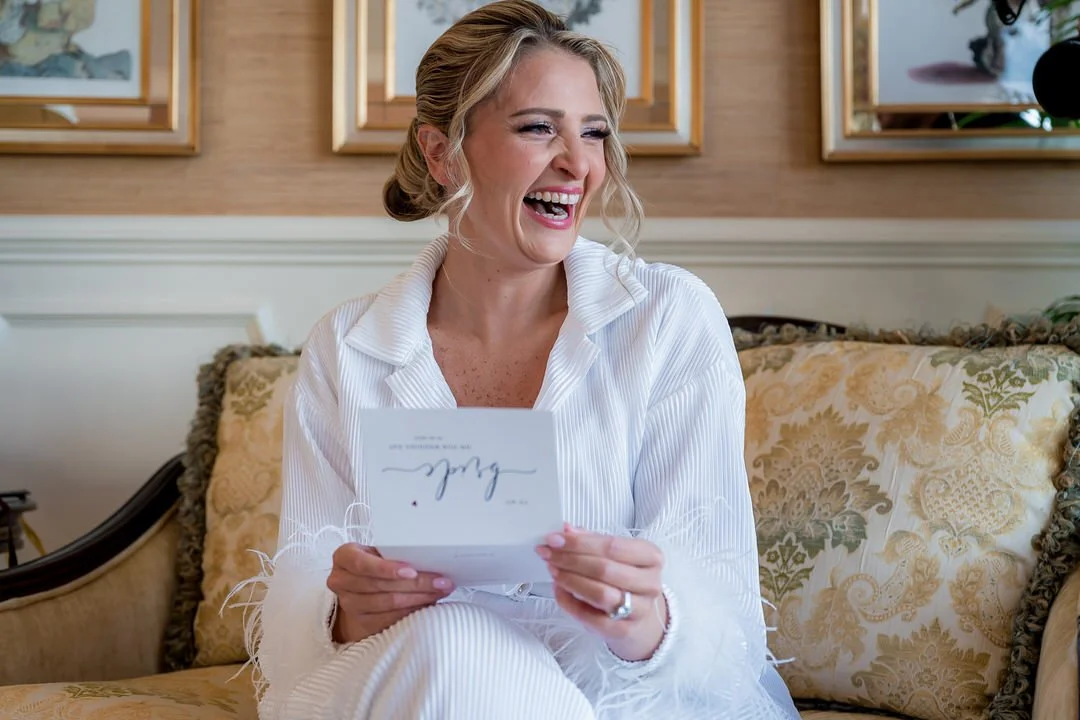 Bride reading a handwritten letter during wedding preparations at Mallard Island Yacht Club