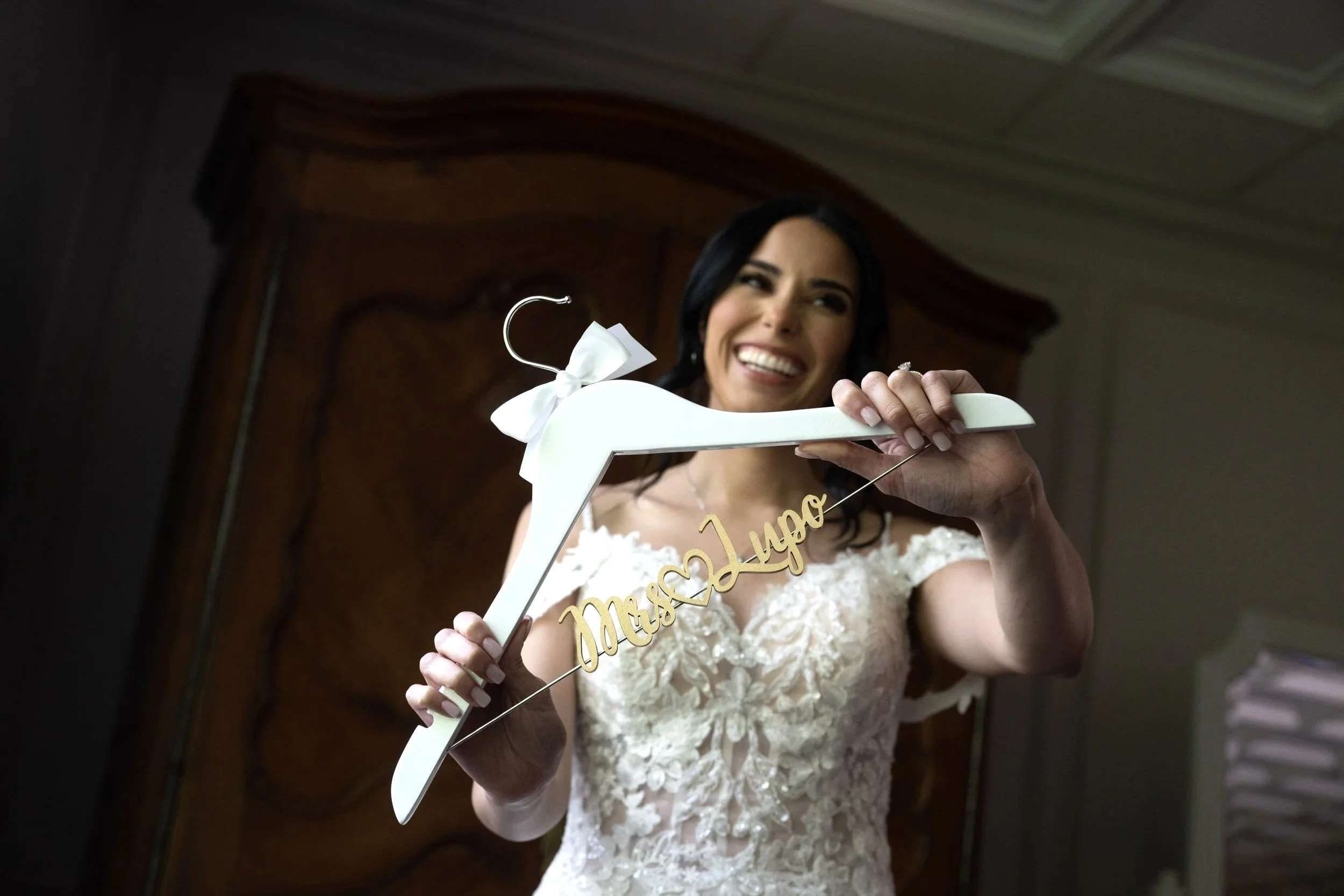 Bride holding personalized hanger with wedding dress before Valley Regency ceremony