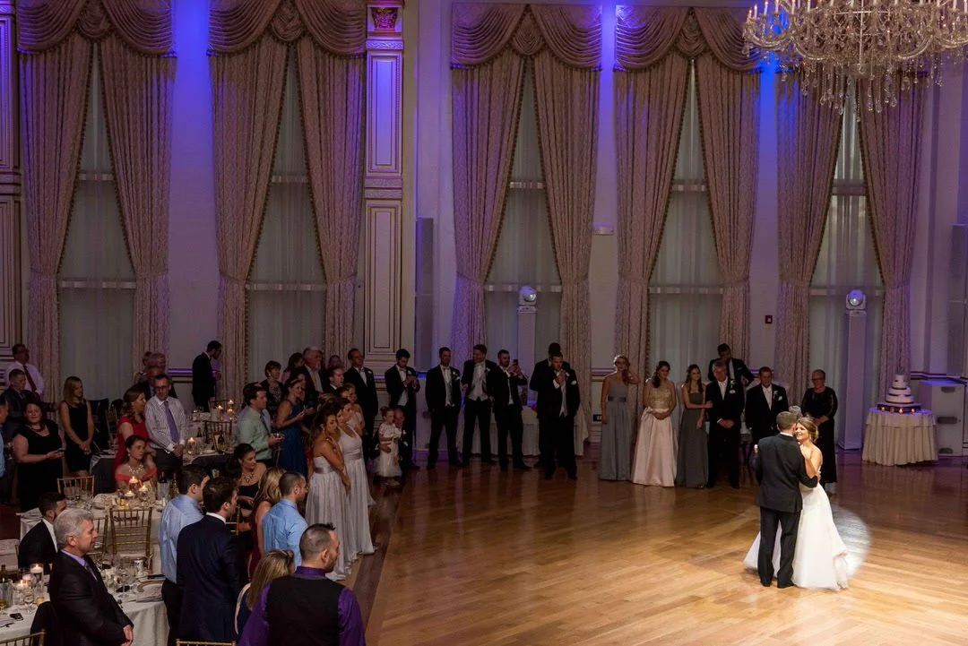 Wedding reception at The Tides featuring a bride and groom sharing their first dance inside the classic estate-style ballroom