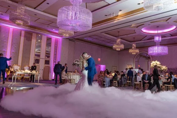 Bride and groom dancing surrounded by family and friends
