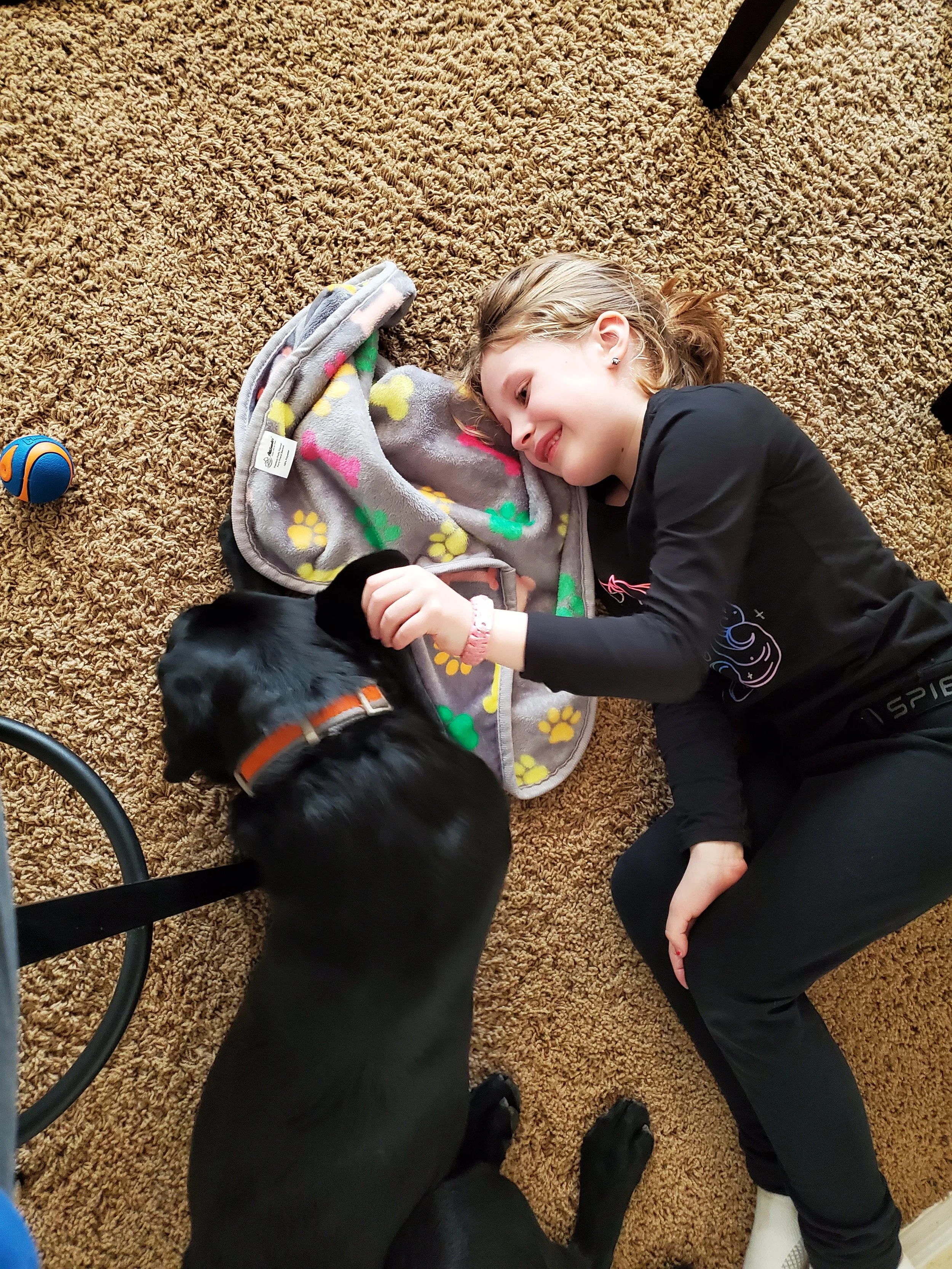 Young girl laying on the floor with her psychiatric service dog