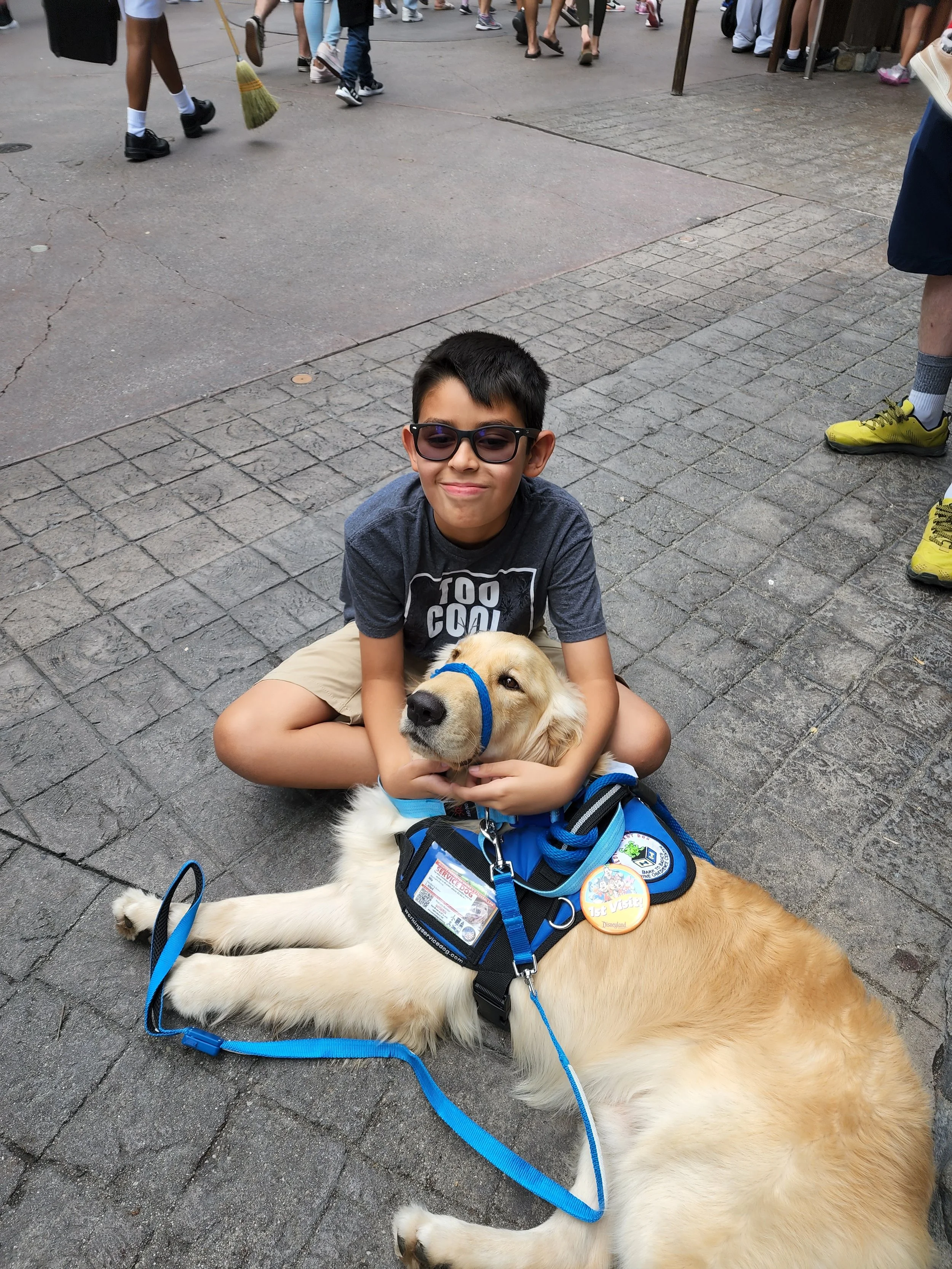 Teen boy sitting outdoors with his golden retriever psychiatric service dog
