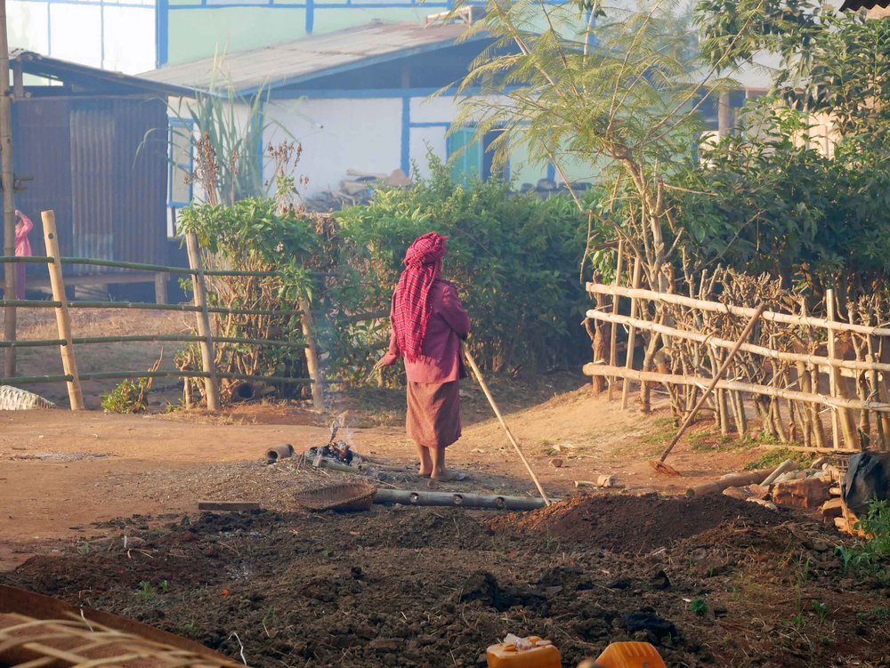  Morning life in the village as a women prepares a small fire for warmth (Feb 21). 