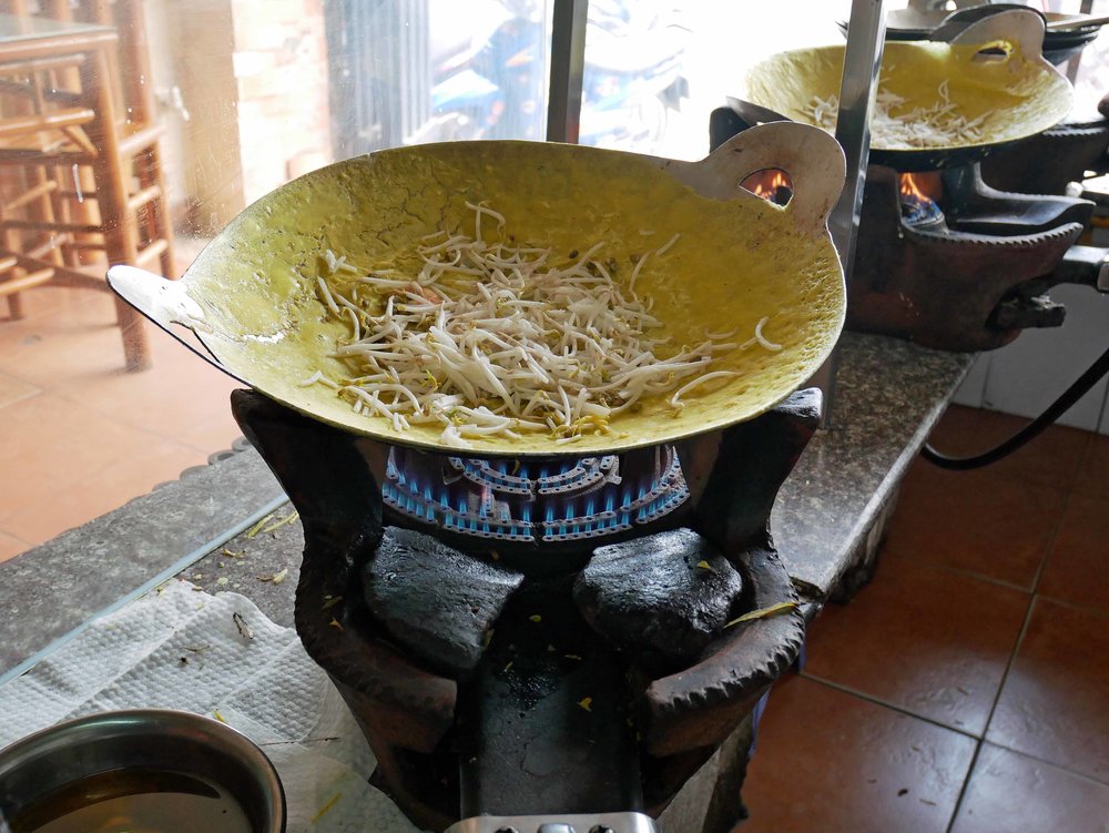  To make Banh Xeo, our lunch that day, the cook spreads rice batter very thin in a wok before adding shrimp, pork and bean sprouts.&nbsp; 