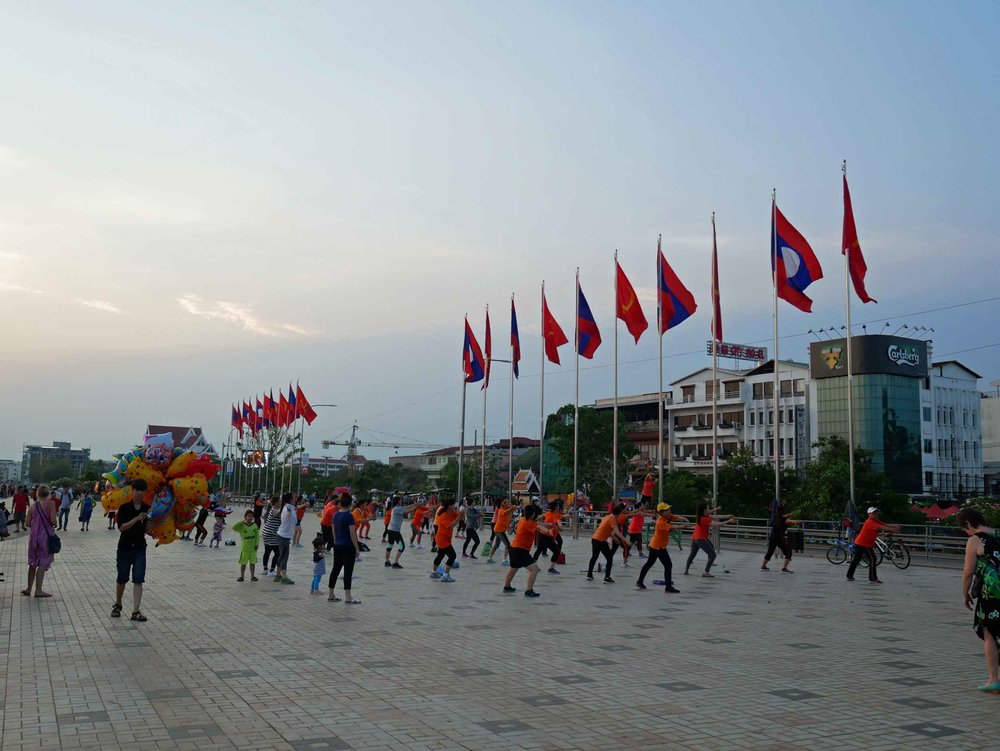  Vientiane, set on the banks of the Mekong River and across from the Thai border, has recently redeveloped its riverfront, which when we visited was full of activity, including exercise groups, food vendors, and couples strolling at sunset (March 30)