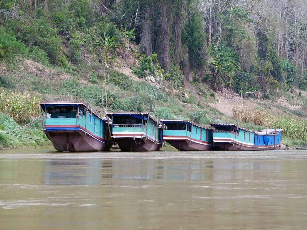  Several slow boats parked along the river's edge.&nbsp; 