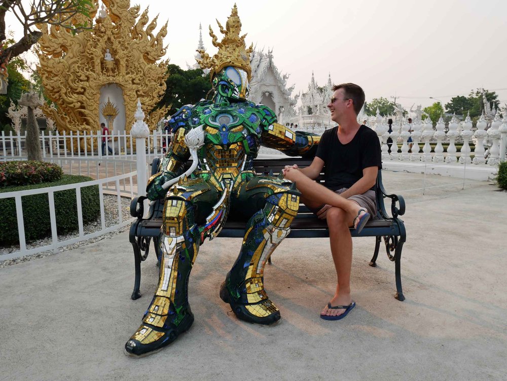  More art installation than traditional temple, Trey sits with one of the many colorful exhibits found around the White Temple.&nbsp; 