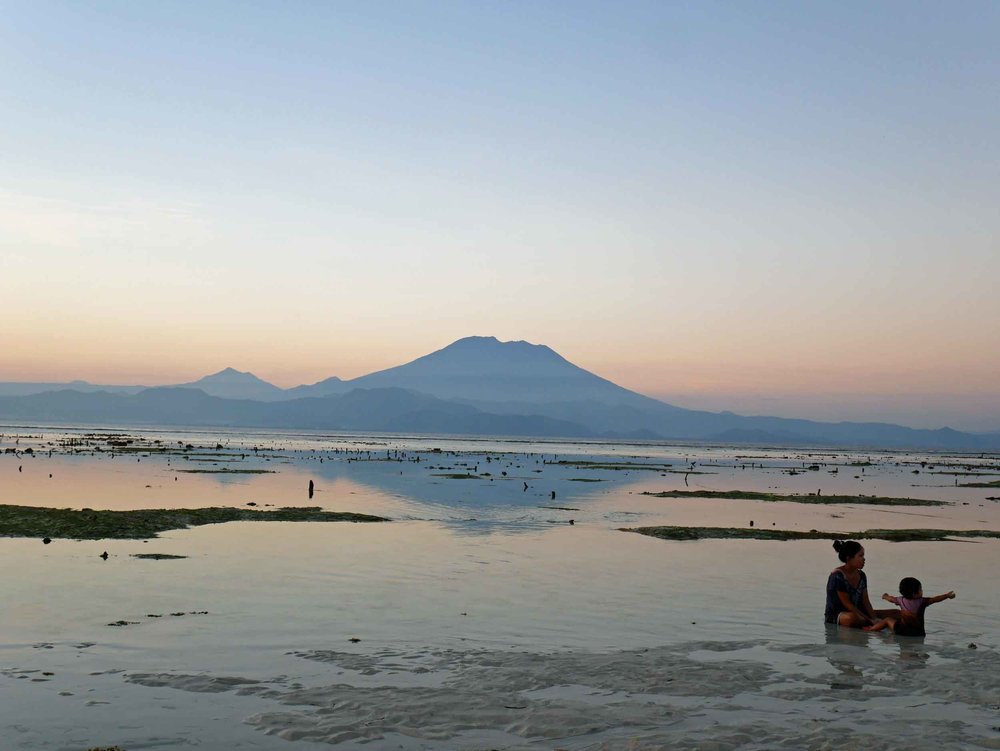  A pregnant Balinese mother plays with her daughter in the low tide of Pemedal Beach. 