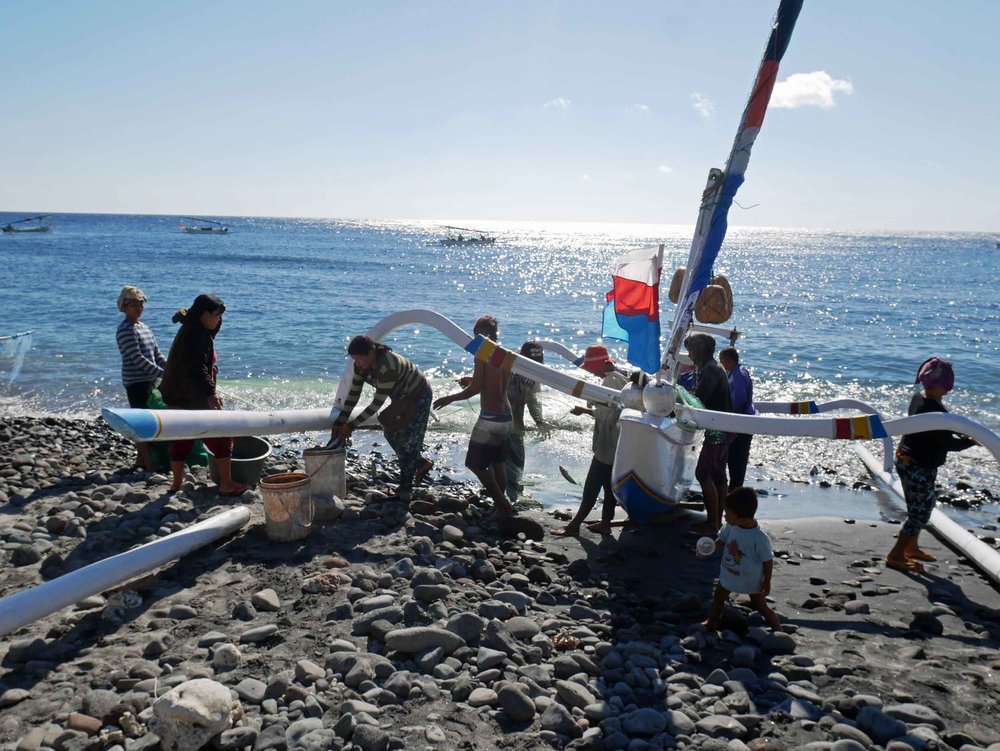  As the lateens approach shore, the crew and local villagers help push the boat onto rocky shore. 
