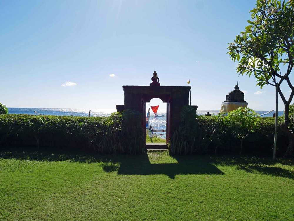  The verdant lawn and crimson gate of Meditasi leads to the black sand beach. 