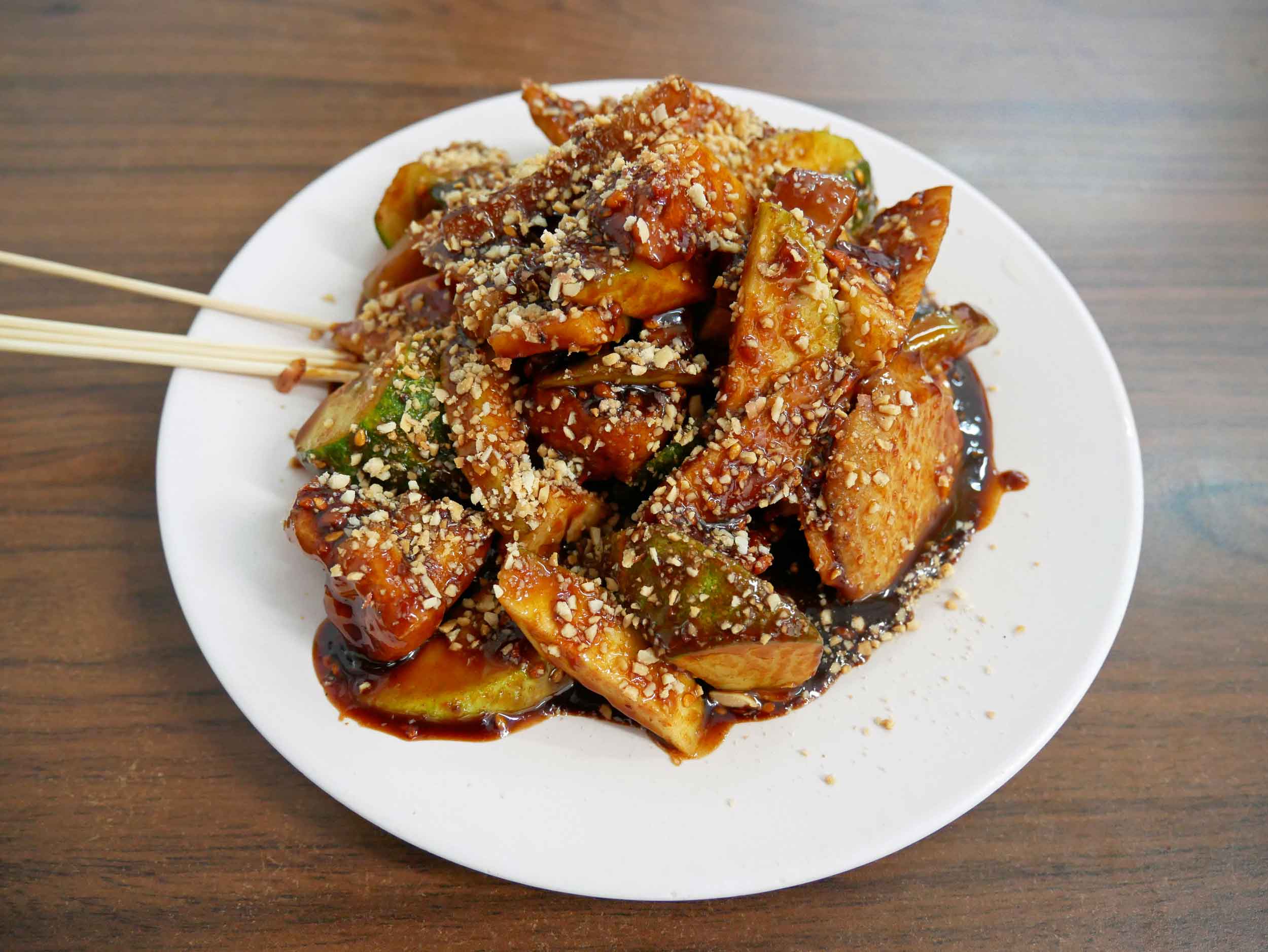  First up,  rojak salad , which translates to "mixture" of raw fruit and vegetables in a thick dressing of tamarind, sugar, vinegar and salt and topped with sesame seeds.&nbsp; 