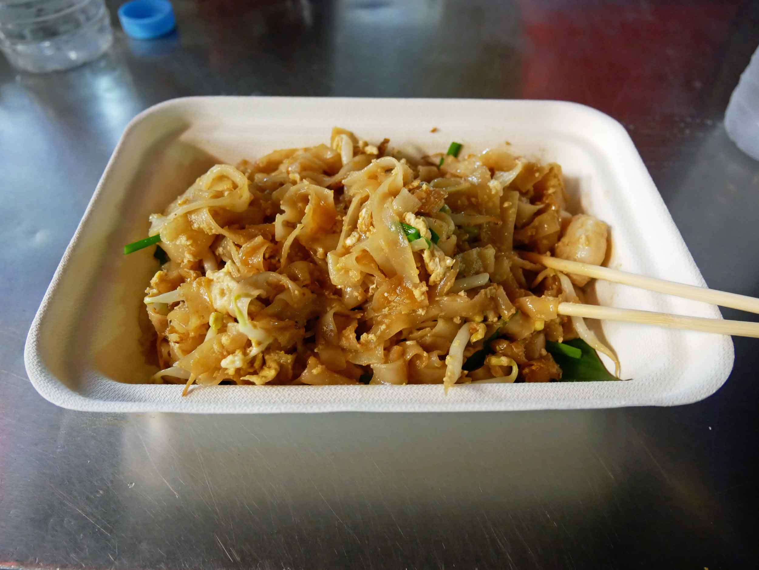  A dish of Gurney's  char kway teow , a Pad Thai-like dish of rice noodles fried with shrimp, green onions, sprouts and egg in a wok.&nbsp; 