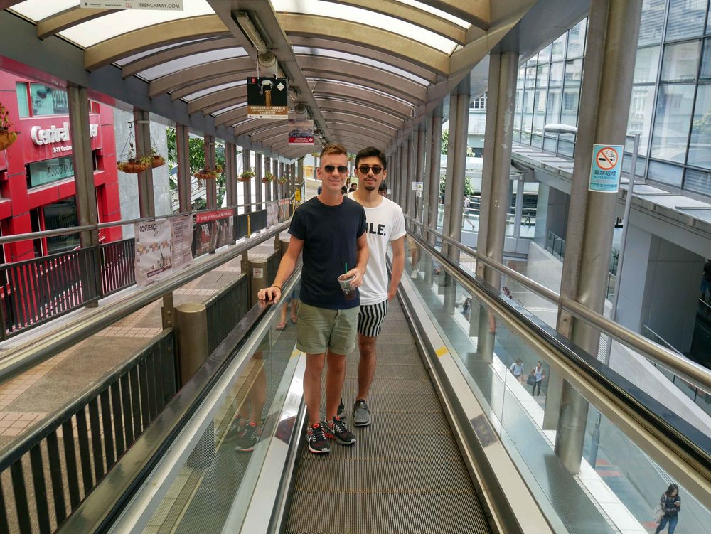  Trey and Nik ride the Central - Mid-Levels outdoor escalator, the longest moving sidewalk system in the world.&nbsp; 