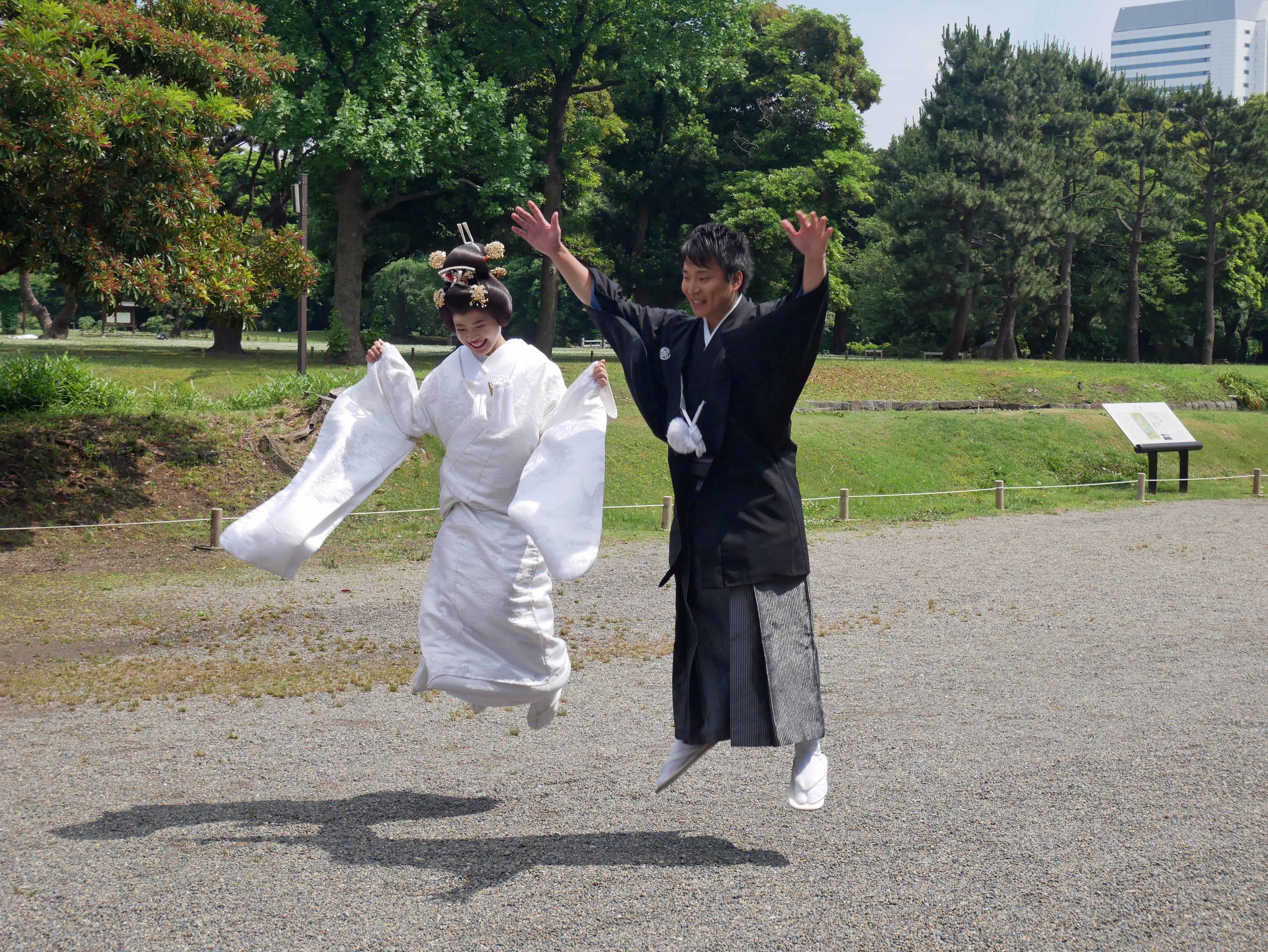  Just married! A couple in traditional national costume jump for joy in Hama-rikyu garden. 