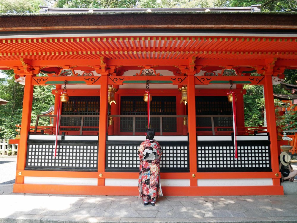  A Japanese woman makes an offering and prayer at one of the many shrines within the complex.&nbsp; 